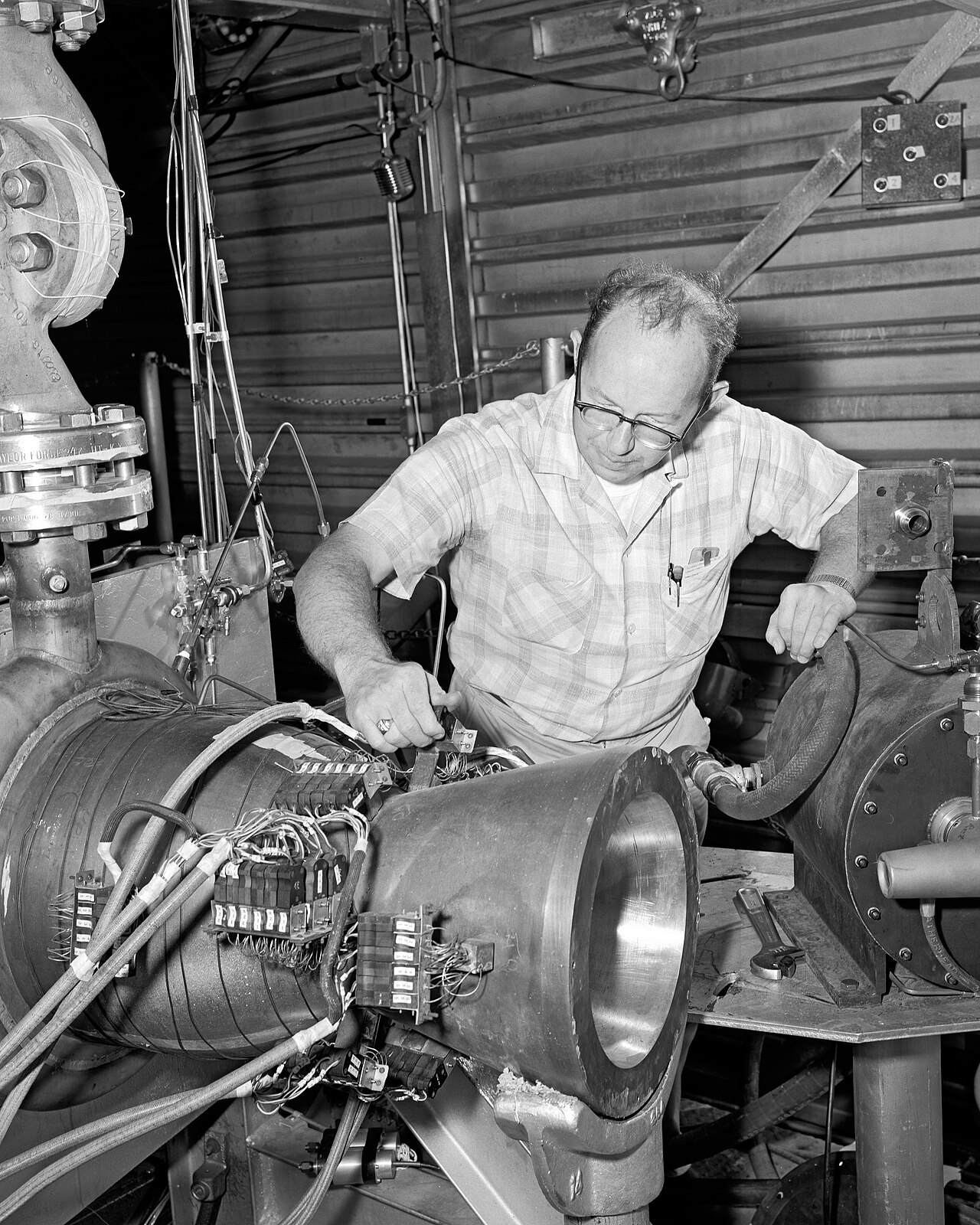 A technician inspects an experimental copper nozzle GRC-1962-P-01214